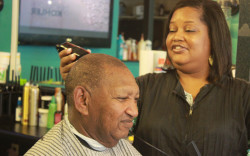 Bridgette Thomas gives regular customer Robert Logan a trim at her Sports Cut shop. She thinks county government is all focused on big industry and not enough of the mid-level businesses that would support families, such as a movie theater, pizza places, styling salons and more.