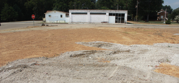 The site of two demolished buildings (foreground) will be the parking lot for a new restaurant (background). Bricks, boards and roofing from the demolished buildings shape the interior design of the new business.