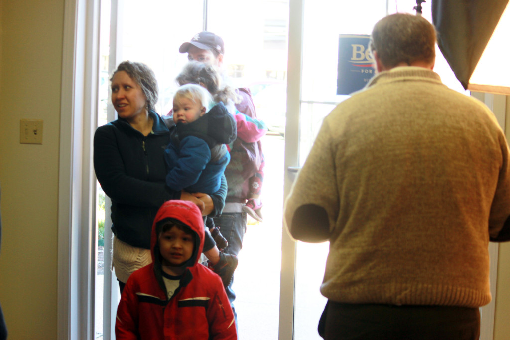 A family of three visits the office. There  was a fully-equipped play room, poster painting and other activities for kids. In the entry area there were laptops set up for volunteers to register to door knock, phone bank or be general office help. 